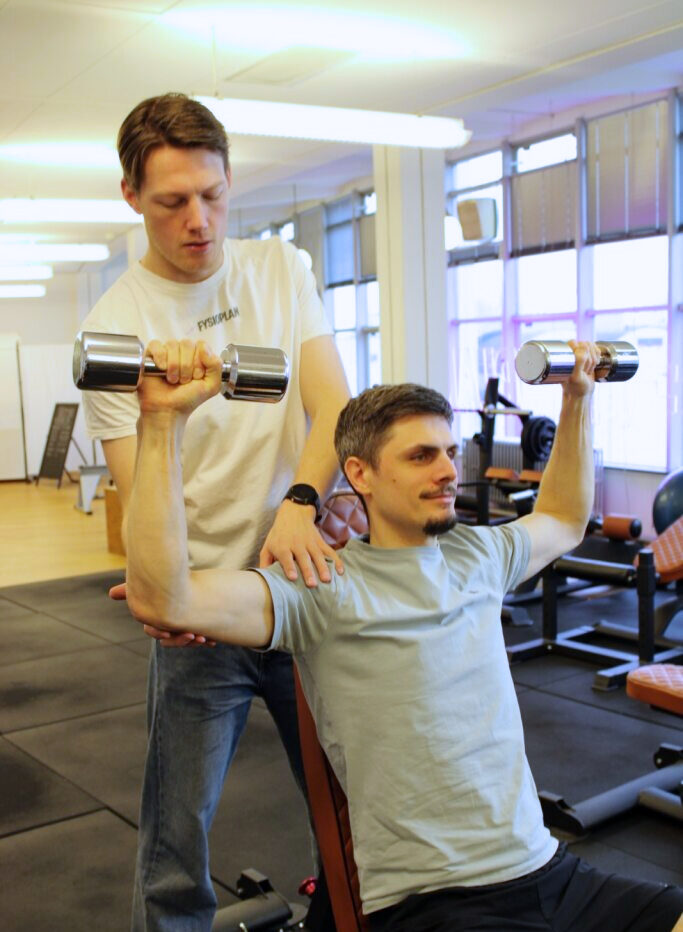 Fysiotherapeut ondersteunt bij shoulder press