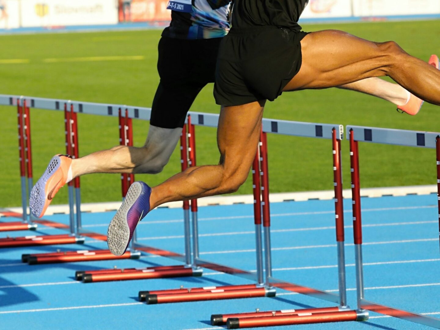 Hordelopers op de atletiekbaan