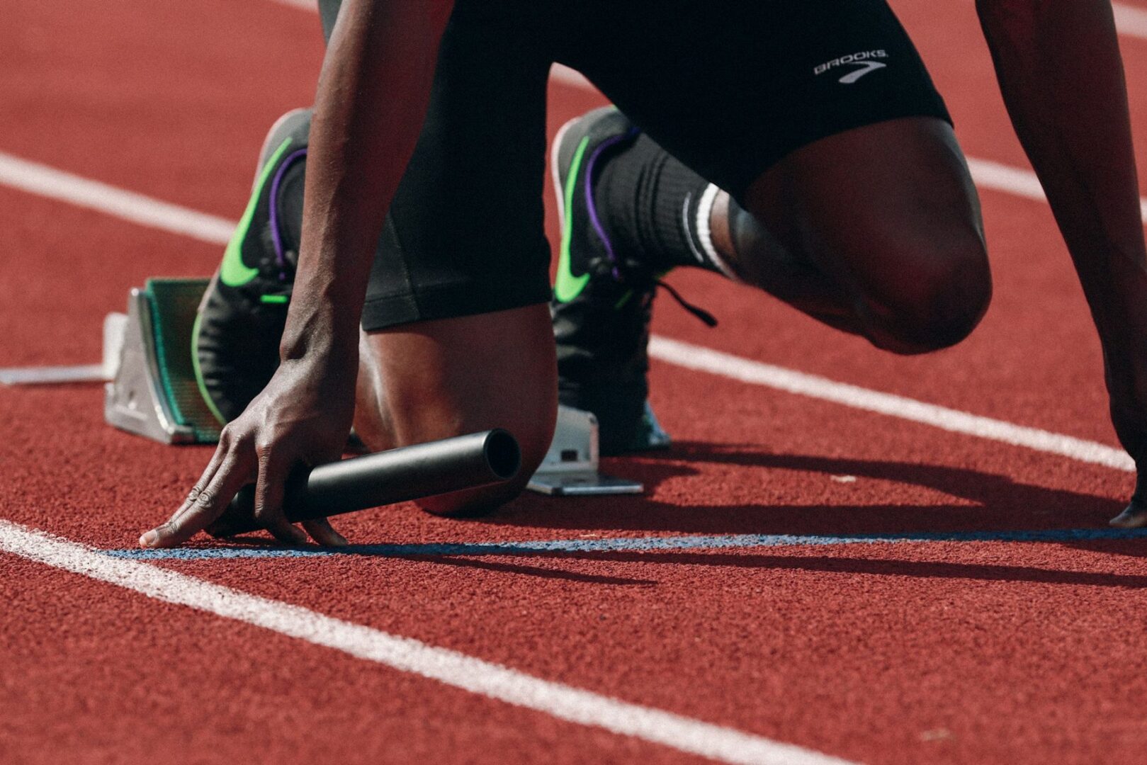 Sprinter in de startblokken op de atletiekbaan