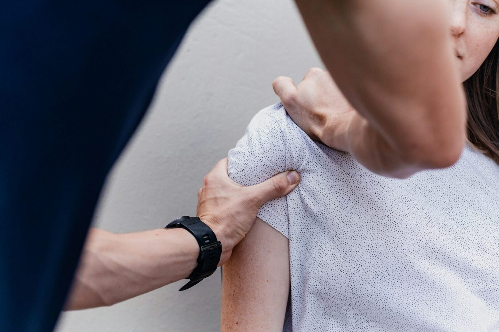 Fysiotherapeut onderzoekt de schouder van een cliënt